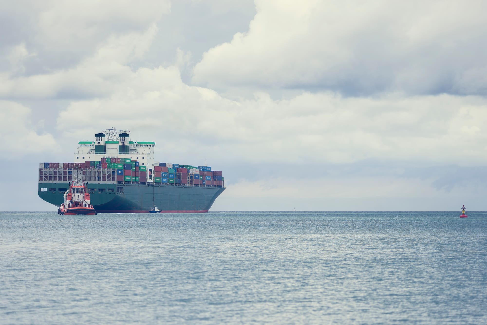 Container ship with a tug at sea
